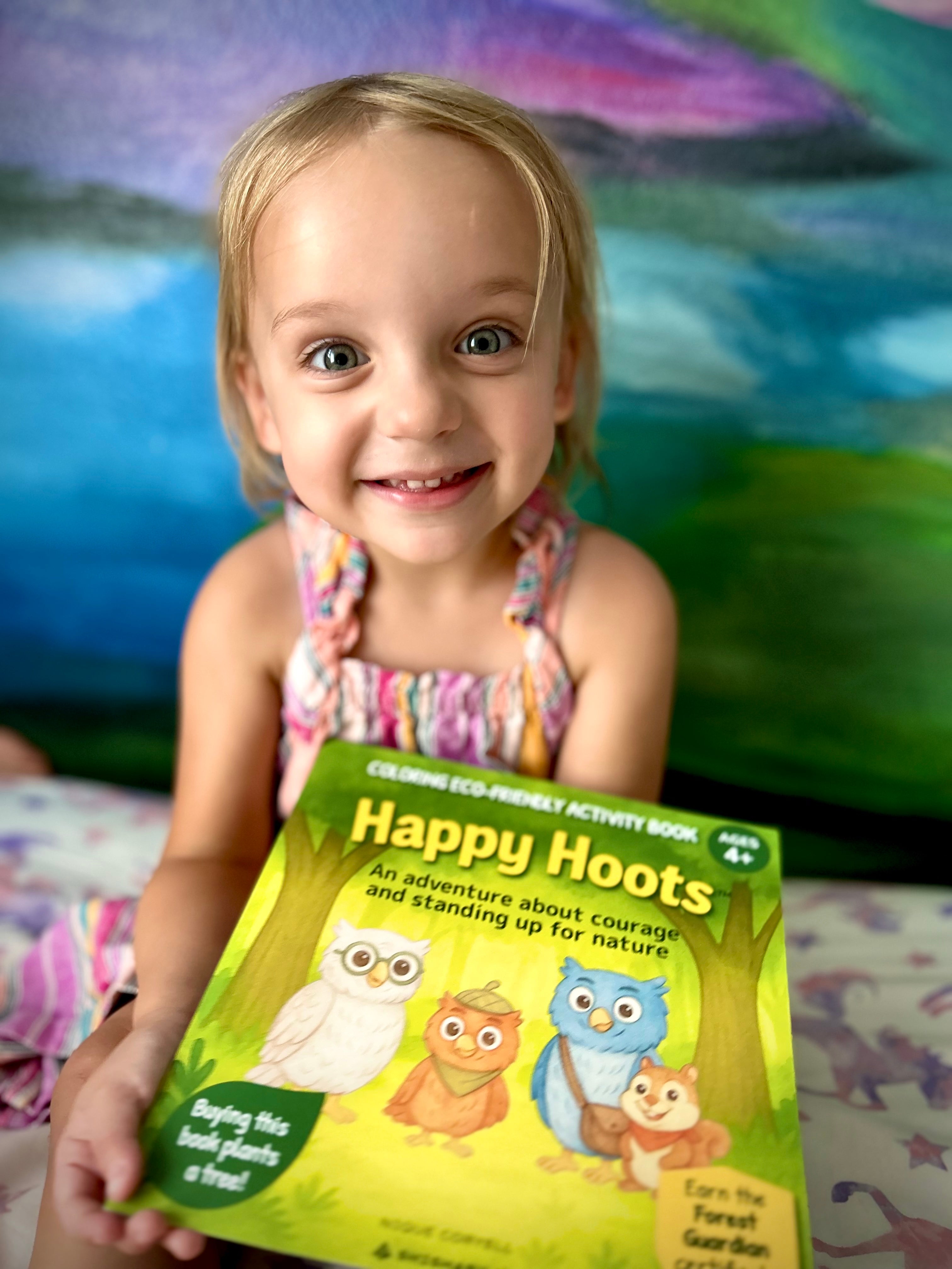 A little girl coloring her Happy Hoots book